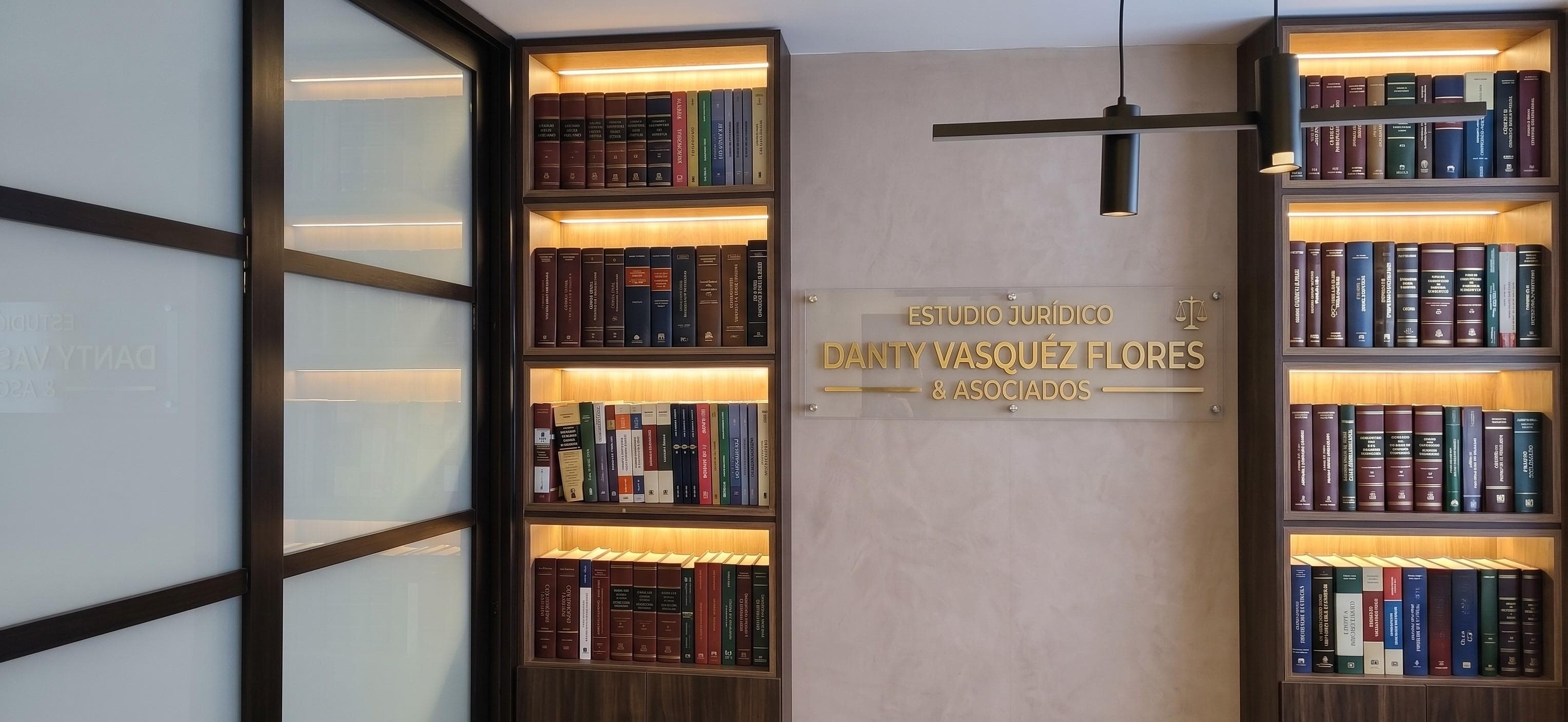Placa del estudio jurídico Danty Vásquez Flores & Asociados junto al librero de la oficina.